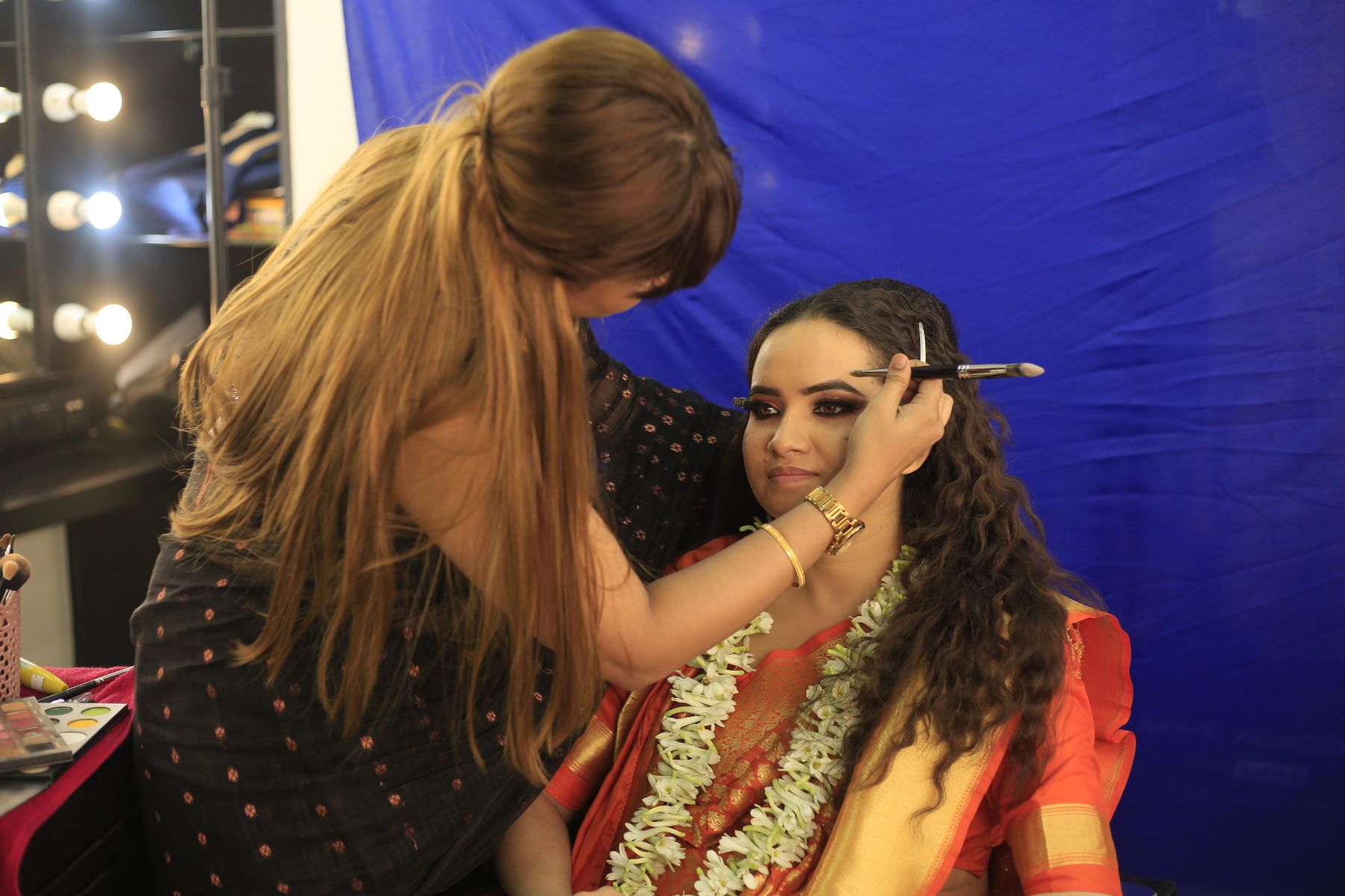 Manisha working backstage under runway lights at Lakmé Fashion Week