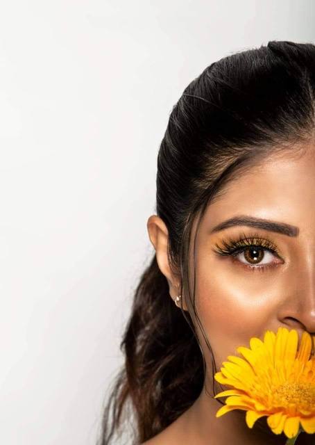 Half-face beauty portrait with yellow gerbera
