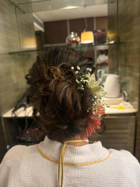 Loose curled updo with gerbera and baby's breath
