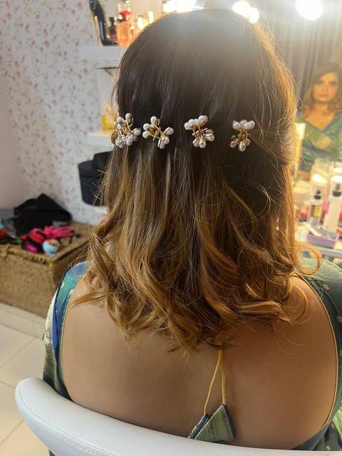 Half-up hairstyle with pearl pins over balayage curls